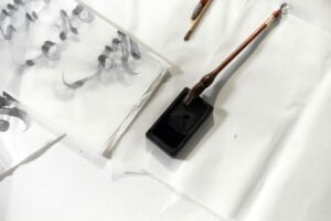 Marouflage d’une œuvre d’art chinois sur papier avec pinceaux et support traditionnel